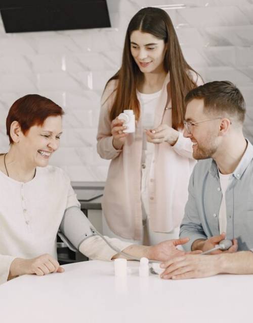 SIL provider with a woman taking her blood pressure